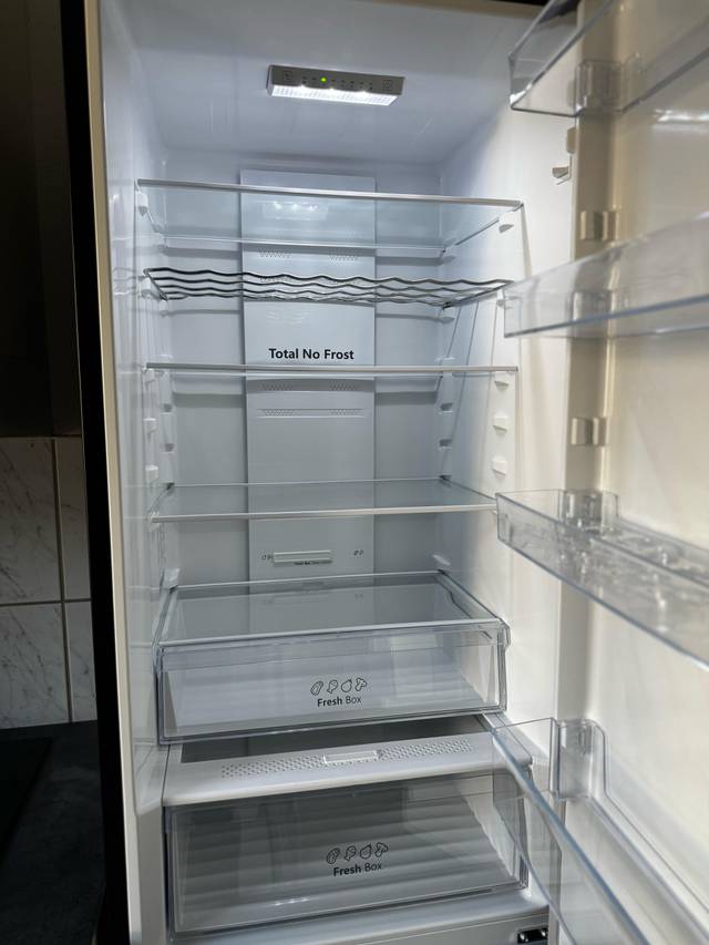 Geöffneter Kühlschrank mit Glasböden und zwei Schubladen in der Monteurwohnung in Frankfurt am Main