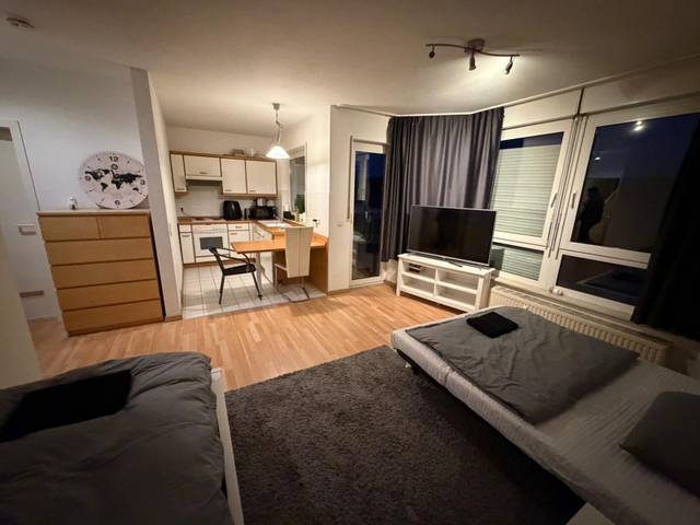 Blick vom Bett über den Wohnraum zur Küchenzeile in einer Monteurwohnung in Niedernhausen