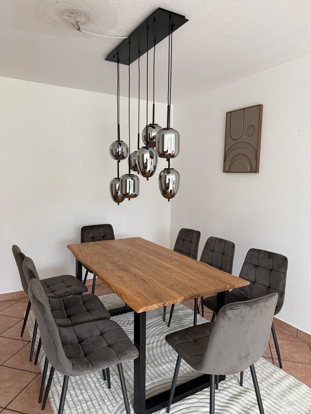 Esstisch mit Holzplatte, Polsterstühlen und Hängelampe in einer Monteurwohnung in Oestrich-Winkel