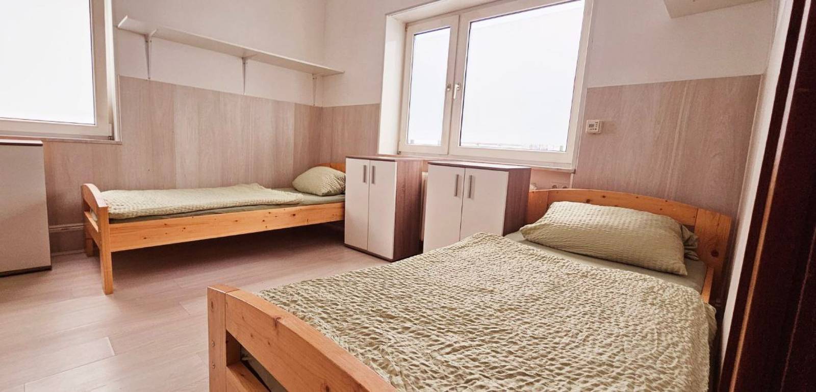 Zwei Einzelbetten aus Holz und zwei weiße Schränke in der Monteurwohnung in Frankfurt am Main