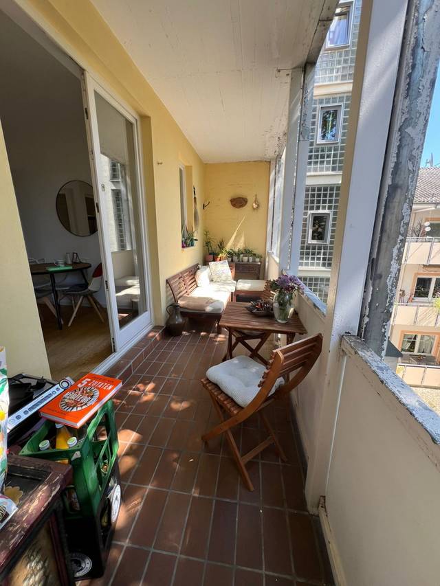 Langer Balkon mit Sitzbank und Klapptisch vor der Balkontür einer Monteurwohnung in Frankfurt am Main