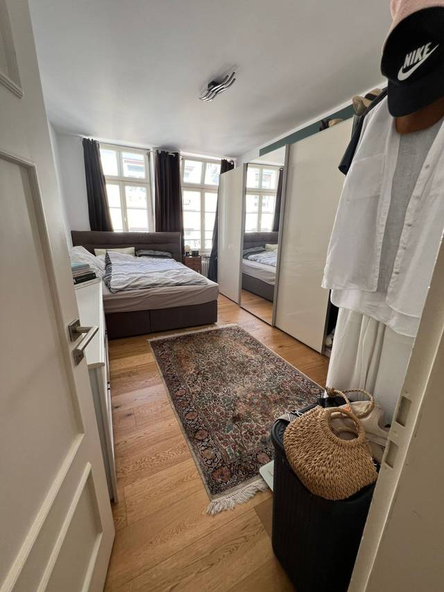 Schlafzimmer mit Bett, Schiebeschrank mit Spiegel und Teppich in einer Monteurwohnung in Frankfurt am Main
