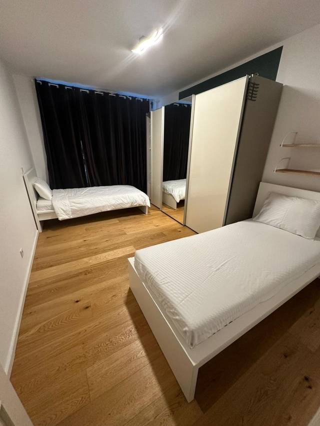 Schlafzimmer mit zwei getrennten Einzelbetten und Schiebeschrank in der Monteurwohnung in Frankfurt am Main