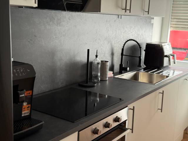 Arbeitsplatte mit Kochfeld, Spüle und Kaffeevollautomat in einer Monteurwohnung in Offenbach am Main