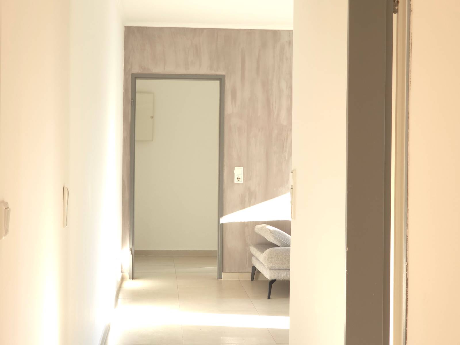 Flur mit Durchblick zu einem Sofa in der Monteurwohnung in Hanau