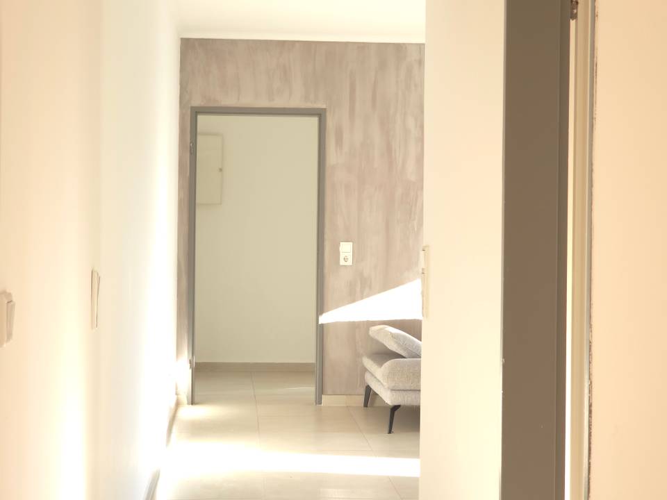 Flur mit Durchblick zu einem Sofa in der Monteurwohnung in Hanau