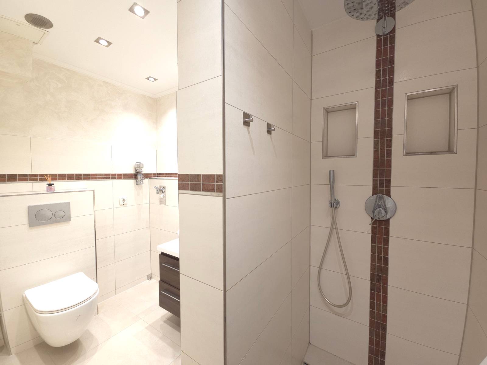 Badezimmer mit Wand-WC und ebenerdiger Dusche in der Monteurwohnung in Hanau