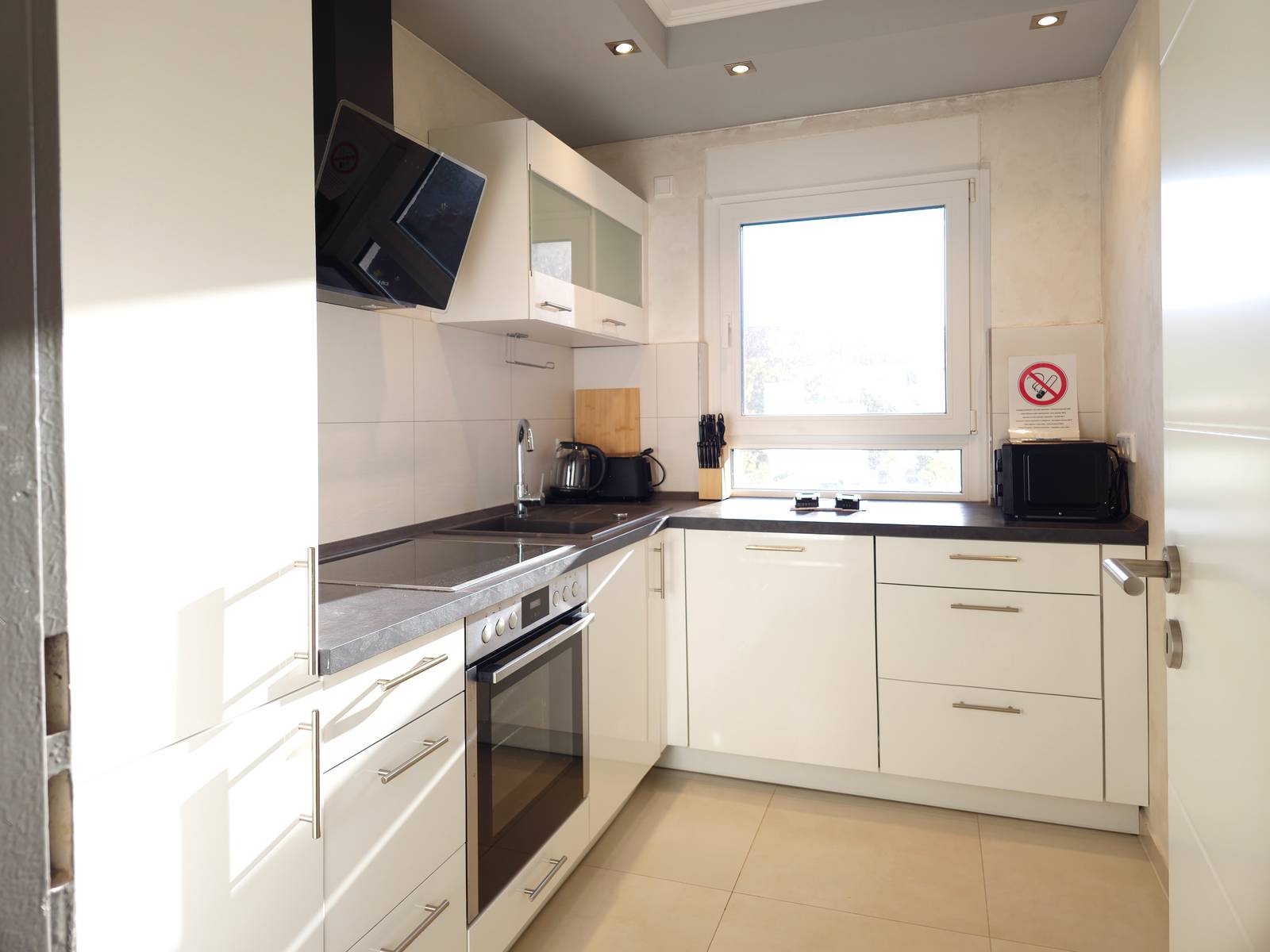 Küche mit Backofen, Kochfeld, Spüle und Wasserkocher in der Monteurwohnung in Hanau