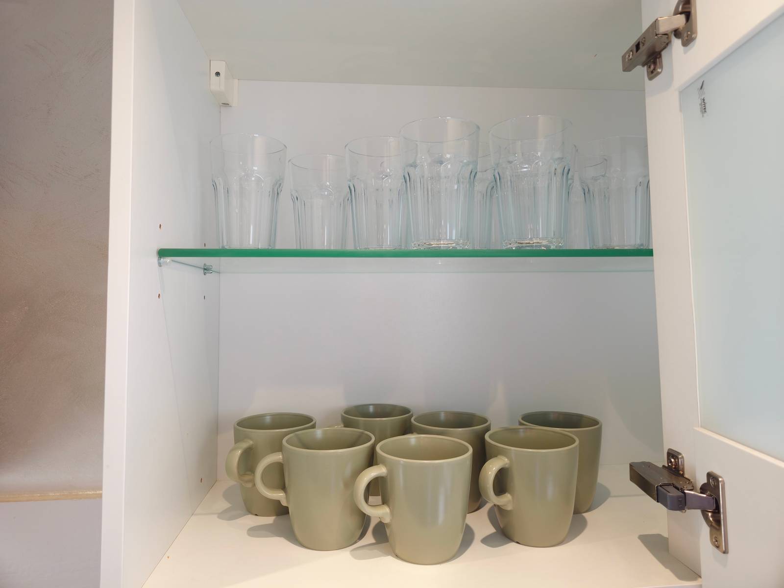Geöffneter Schrank mit Trinkgläsern und Tassen in der Monteurwohnung in Hanau