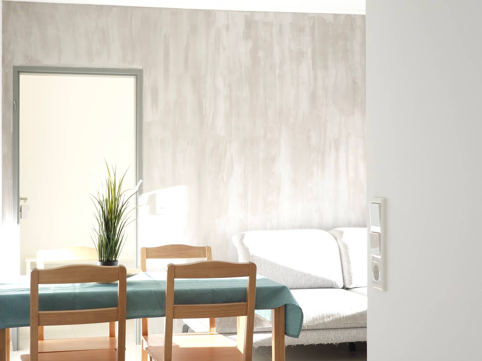 Esstisch mit Stühlen und Sofa im Hintergrund in der Monteurwohnung in Hanau