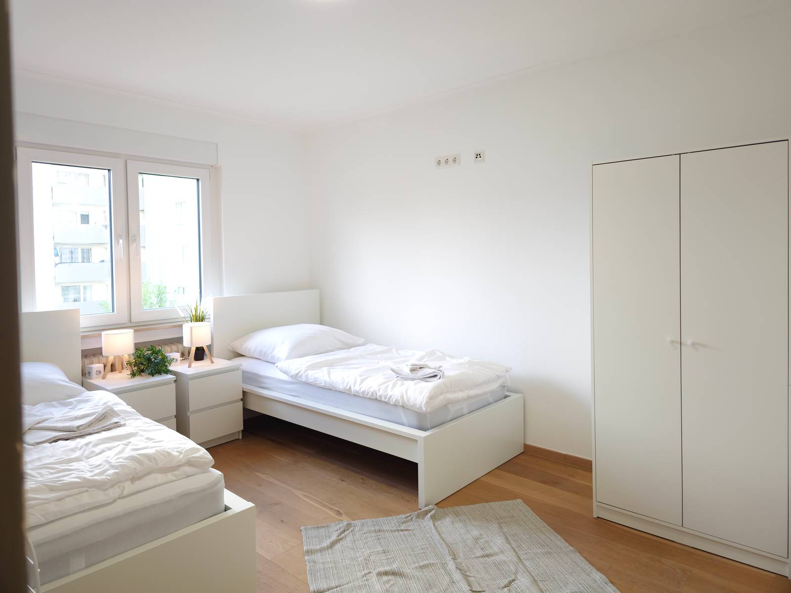 Zimmer mit zwei Einzelbetten, Nachttischen und Kleiderschrank in der Monteurwohnung in Hanau