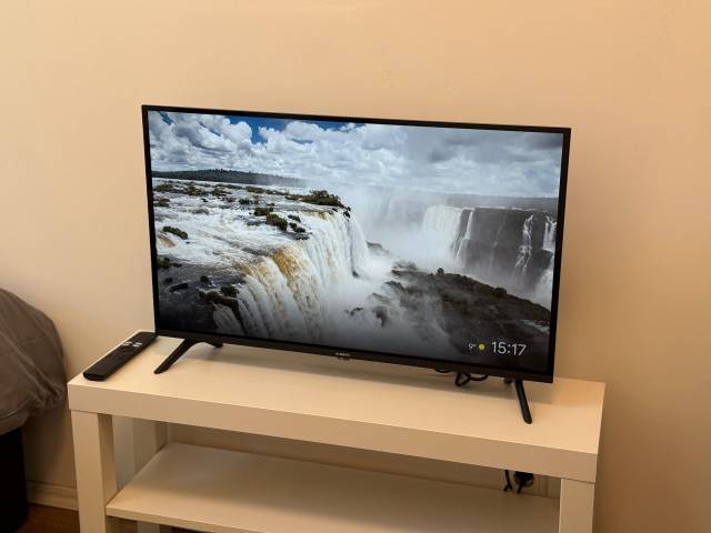 Fernseher mit Fernbedienung auf einem weißen Regal in der Monteurwohnung in Frankfurt am Main