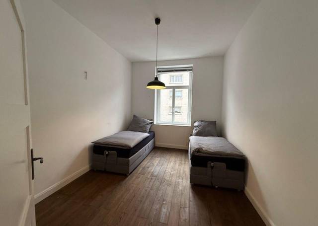 Zweites Zimmer mit zwei getrennten Einzelbetten und Pendelleuchte in der Monteurwohnung in Frankfurt am Main