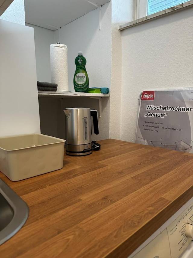 Holzarbeitsplatte mit Wasserkocher, Spüle und Regal in der Monteurwohnung in Wiesbaden