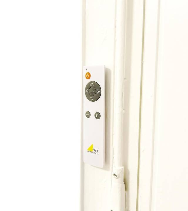 Weiße Fernbedienung für die Deckenleuchte an der Wand in einer Monteurwohnung in Wiesbaden