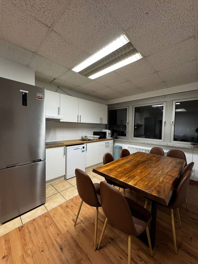 Holztisch mit braunen Stühlen vor der Küchenzeile in der Monteurwohnung in Frankfurt am Main
