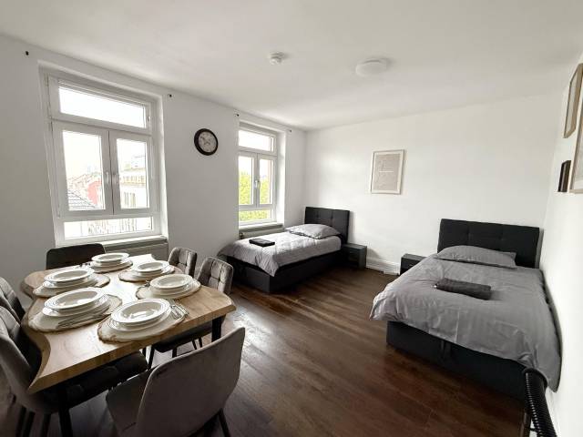 Raum mit zwei Einzelbetten und gedecktem Esstisch in der Monteurwohnung in Frankfurt am Main