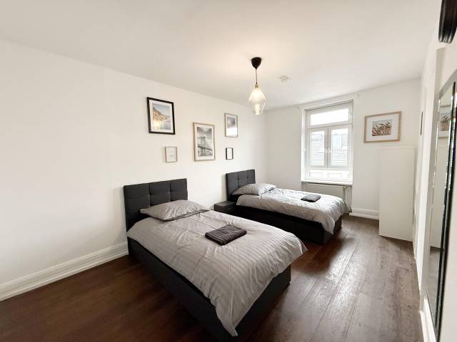 Schlafzimmer mit zwei Einzelbetten, Fenster und Schrank in einer Monteurwohnung in Frankfurt am Main