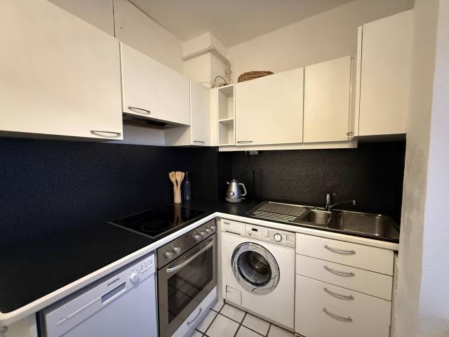 Eckküche mit Backofen, Kochfeld, Spülmaschine und Waschmaschine in der Monteurwohnung in Frankfurt am Main
