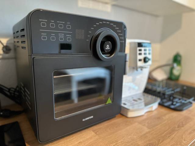 Heißluftfritteuse neben einem Kaffeevollautomaten auf der Arbeitsplatte der Monteurwohnung in Mainz