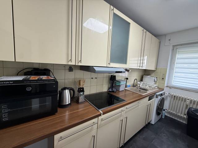 Küchenzeile mit Kochfeld, Spüle, Mini-Backofen und Waschmaschine in der Monteurwohnung in Niedernhausen