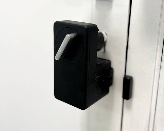 Schwarzes elektronisches Türschloss an einer weißen Tür der Monteurwohnung in Walluf